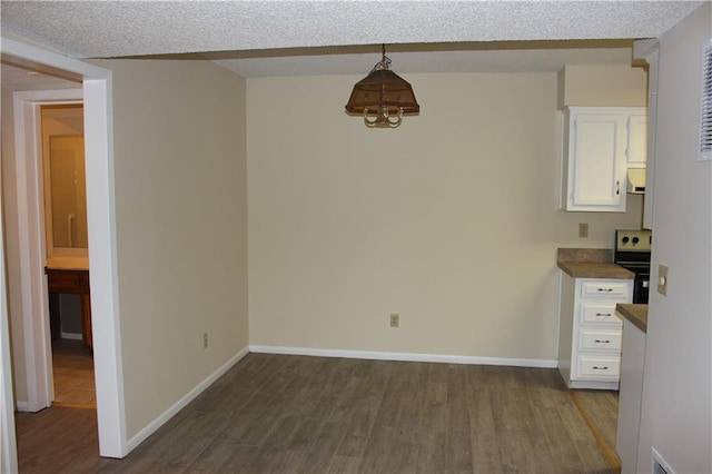 unfurnished dining area featuring hardwood / wood-style floors and a textured ceiling