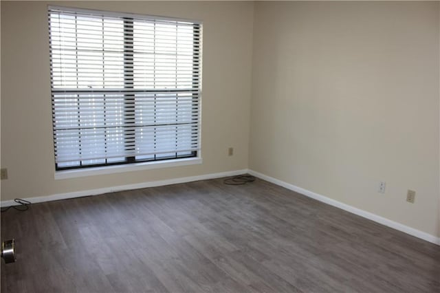 unfurnished room with dark hardwood / wood-style flooring