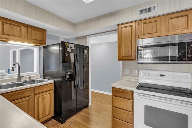 kitchen with black fridge with ice dispenser, sink, light hardwood / wood-style flooring, electric range, and decorative backsplash