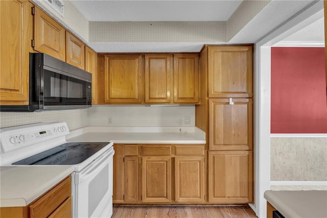 kitchen with light wood-type flooring and white range with electric stovetop