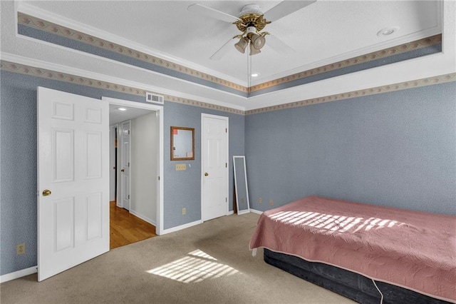 carpeted bedroom with crown molding and ceiling fan