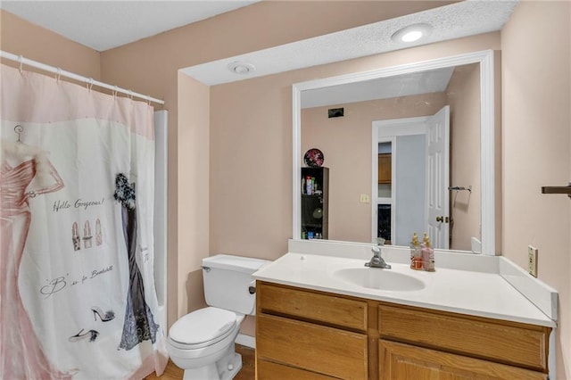 bathroom featuring walk in shower, vanity, and toilet