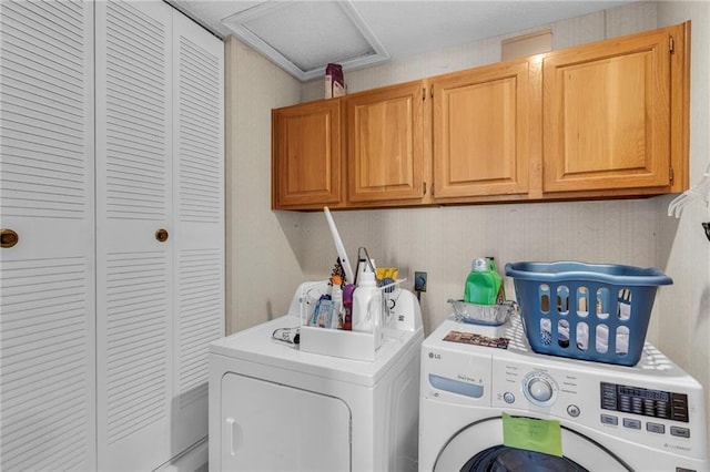 washroom with cabinets and washing machine and clothes dryer