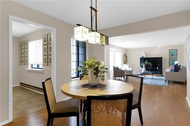 dining area with a baseboard radiator and light wood-type flooring