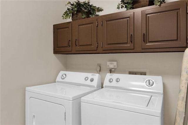 washroom with cabinets and washing machine and clothes dryer