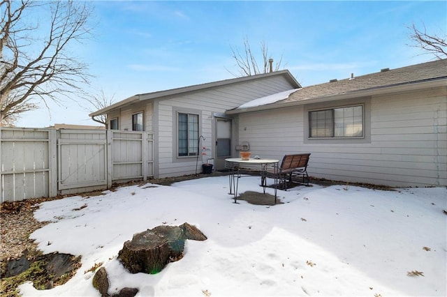 view of snow covered back of property