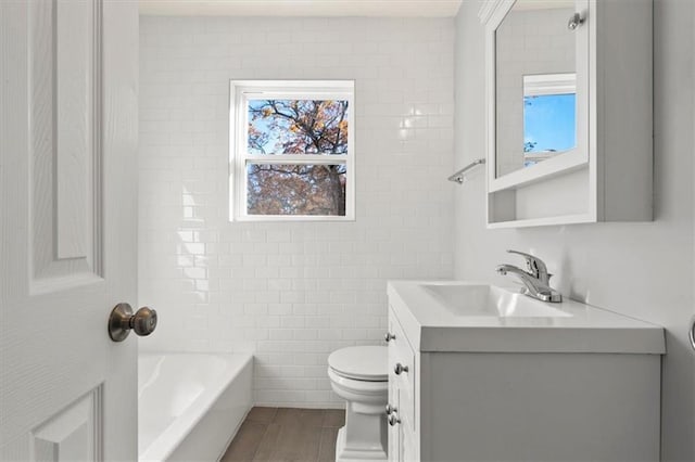 bathroom with vanity, a healthy amount of sunlight, tile walls, and toilet