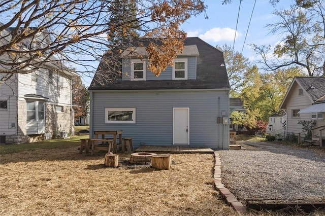 rear view of house featuring a yard and an outdoor fire pit