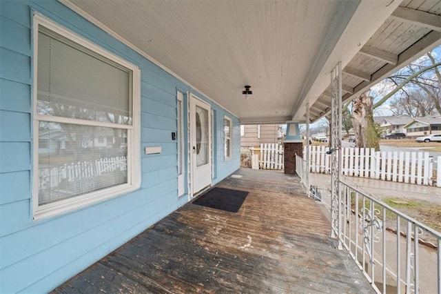 view of patio with fence and a porch