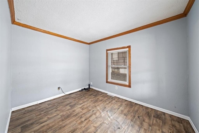 spare room featuring crown molding, a textured ceiling, baseboards, and wood finished floors