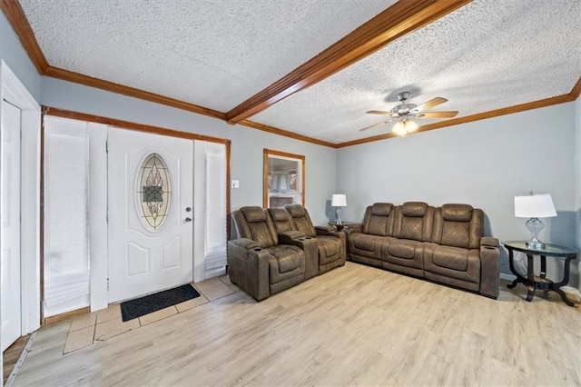 living area featuring ceiling fan, a textured ceiling, ornamental molding, and wood finished floors