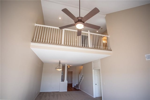 staircase featuring ceiling fan and carpet