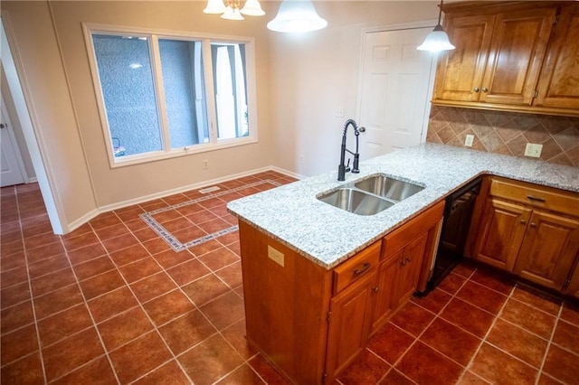 kitchen with sink, hanging light fixtures, light stone countertops, decorative backsplash, and kitchen peninsula