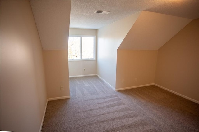 additional living space featuring lofted ceiling, light carpet, and a textured ceiling