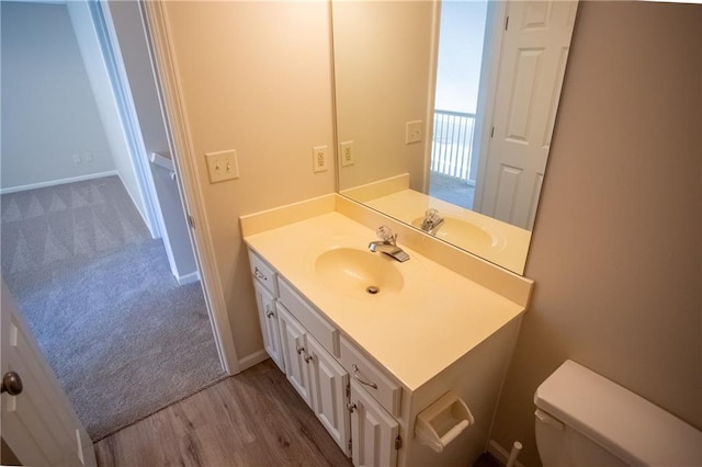 bathroom with vanity, wood-type flooring, and toilet