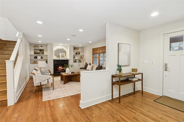 living room with light hardwood / wood-style floors and built in features