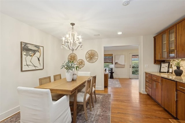 dining room with dark wood-type flooring and an inviting chandelier