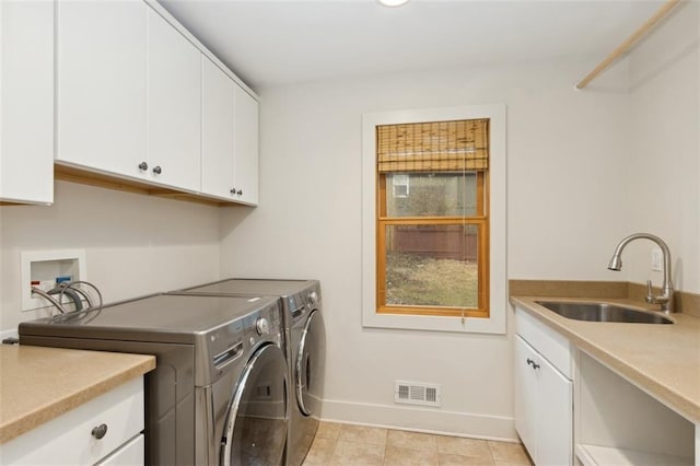 washroom with sink, washer and clothes dryer, cabinets, and light tile patterned flooring