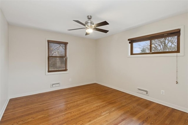 spare room featuring hardwood / wood-style floors, a healthy amount of sunlight, and ceiling fan