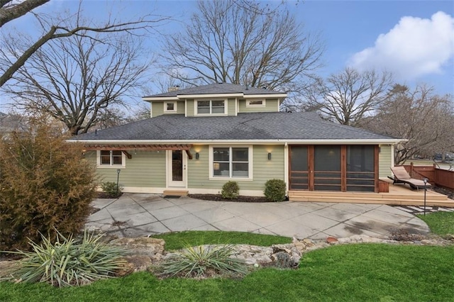 view of front facade featuring a wooden deck, a front lawn, and a sunroom