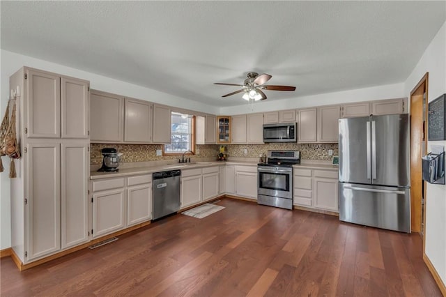 kitchen with stainless steel appliances, dark hardwood / wood-style flooring, sink, and decorative backsplash