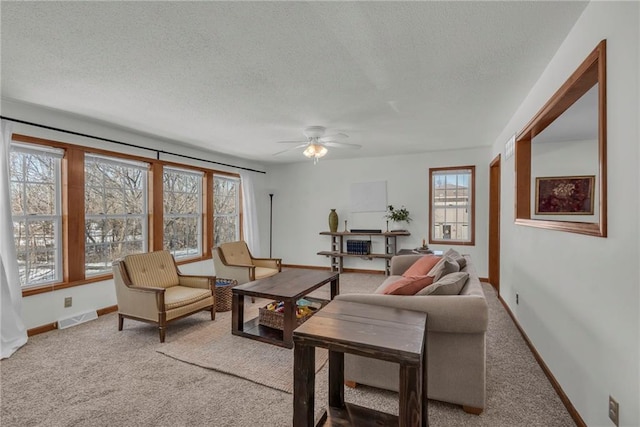 living room featuring ceiling fan, a textured ceiling, and carpet