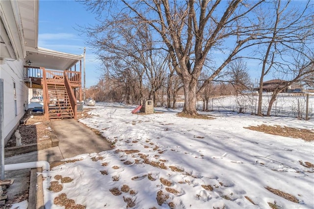 yard covered in snow with a wooden deck