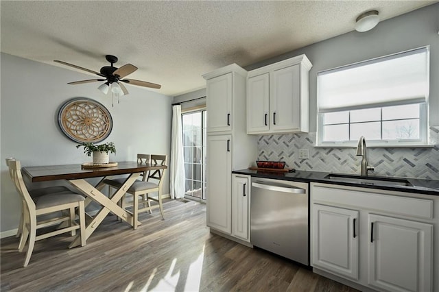 kitchen with white cabinetry, dishwasher, sink, dark hardwood / wood-style flooring, and decorative backsplash