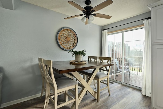 dining area with ceiling fan, wood-type flooring, and a textured ceiling