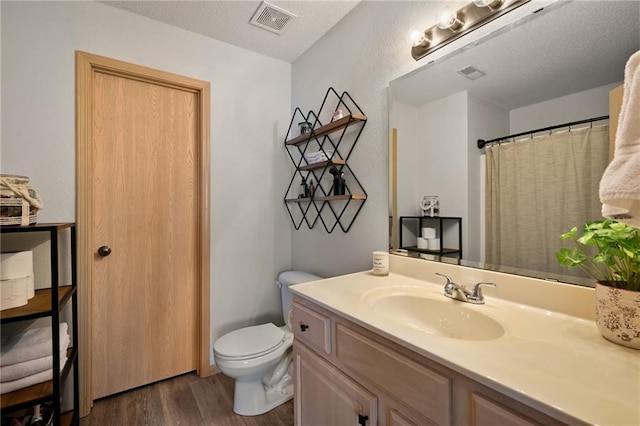 bathroom featuring vanity, wood-type flooring, and toilet