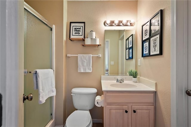 bathroom featuring vanity, toilet, and an enclosed shower