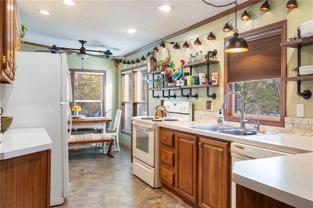 kitchen featuring pendant lighting, sink, white appliances, ceiling fan, and a textured ceiling