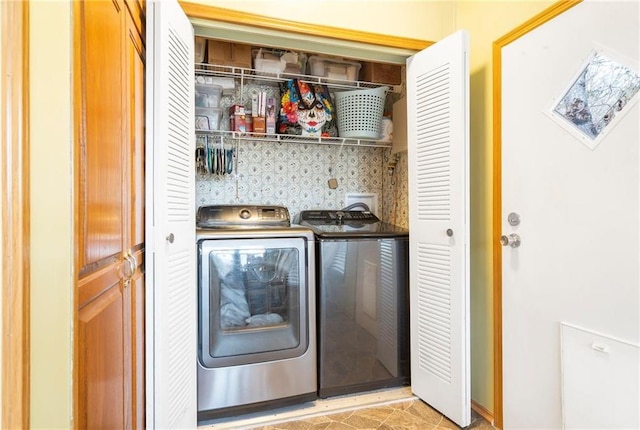 laundry room featuring light tile patterned flooring and washing machine and dryer