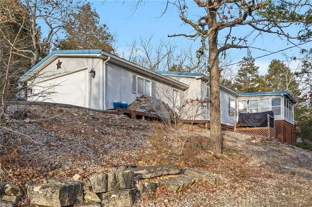 exterior space with a garage and a sunroom