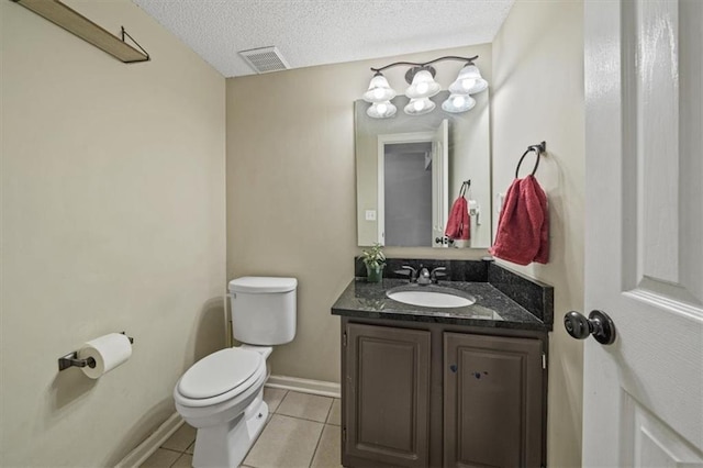 bathroom with tile patterned flooring, vanity, a textured ceiling, and toilet