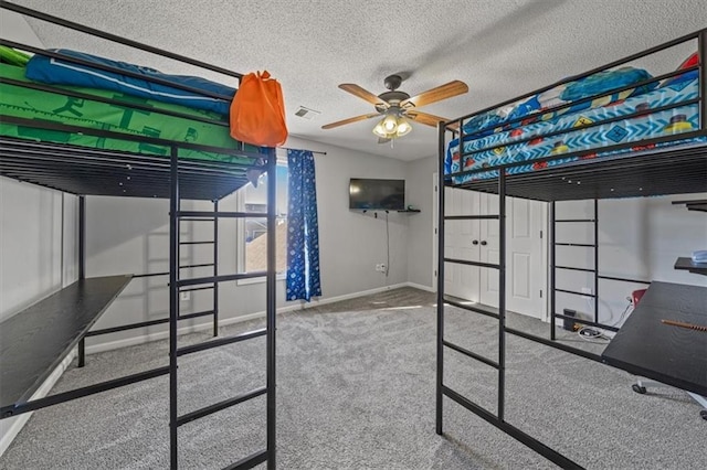 carpeted bedroom featuring ceiling fan and a textured ceiling