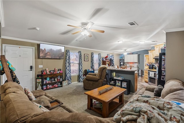 carpeted living room with ceiling fan and ornamental molding