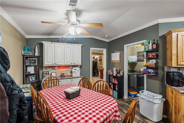 dining area with dark wood-type flooring, ceiling fan, ornamental molding, and vaulted ceiling