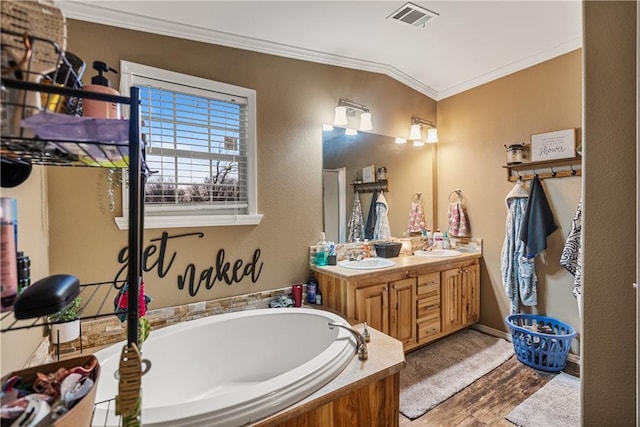 bathroom featuring vanity, a bath, wood-type flooring, ornamental molding, and vaulted ceiling