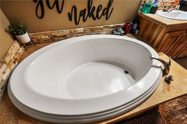 bathroom with vanity and a washtub