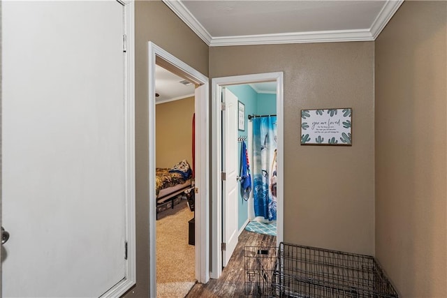 corridor with ornamental molding and hardwood / wood-style floors