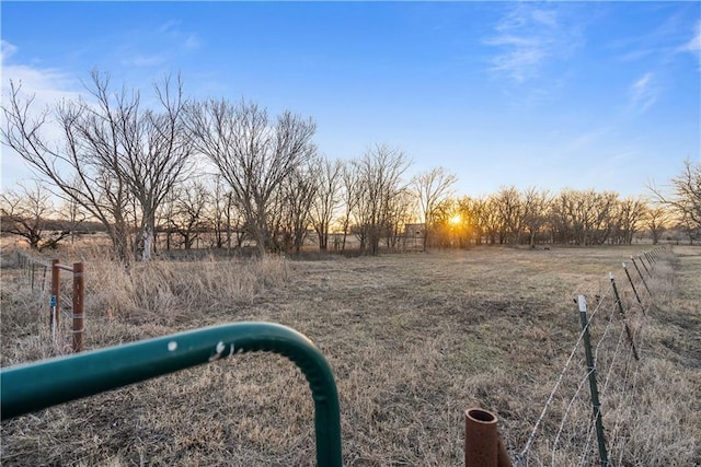 yard at dusk featuring a rural view