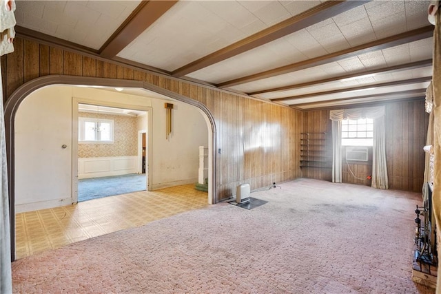 empty room with beamed ceiling, light colored carpet, and cooling unit