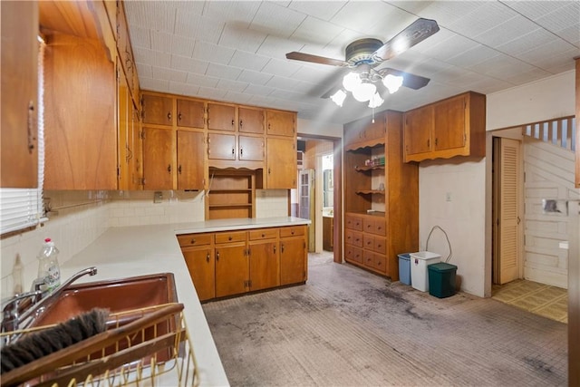 kitchen with ceiling fan, light colored carpet, sink, and backsplash