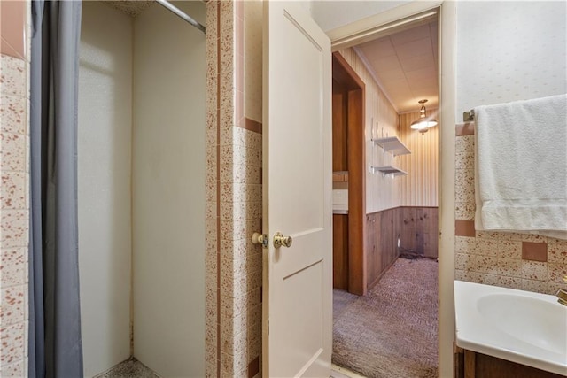 bathroom featuring vanity and wood walls