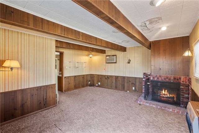 interior space with a fireplace, wood walls, beamed ceiling, and carpet