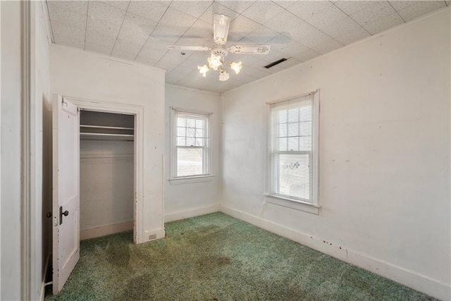 unfurnished bedroom with dark carpet and a closet