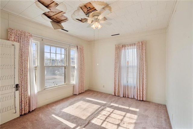 empty room featuring crown molding, light colored carpet, and ceiling fan