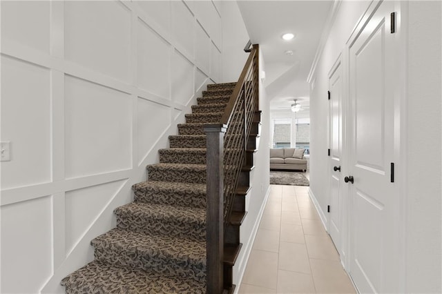 stairs with ceiling fan and tile patterned floors