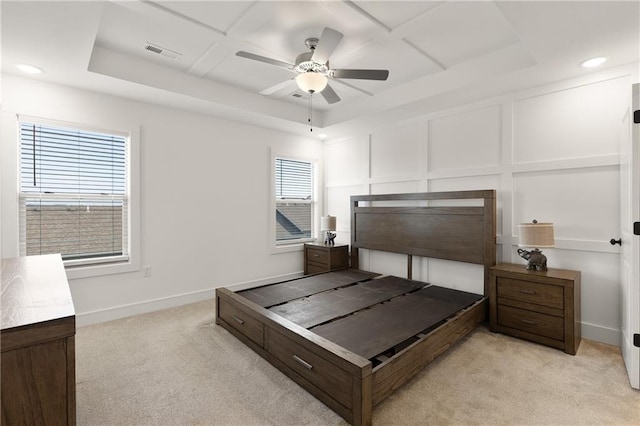 carpeted bedroom with ceiling fan, a tray ceiling, and coffered ceiling